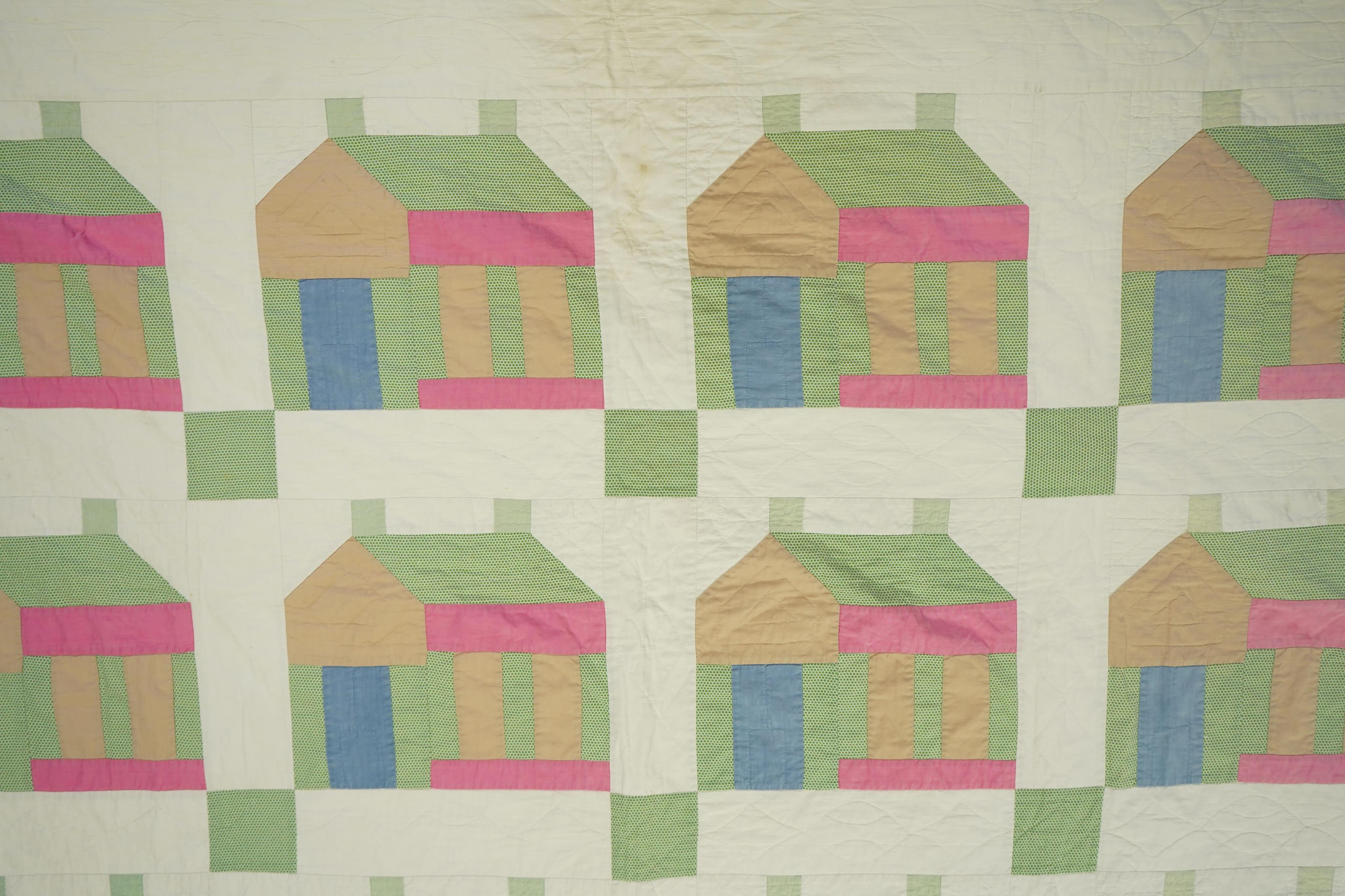 A 1930’s American quilt from Vermont. Quilted in large patchwork ‘house’ motifs, repeating the same four colours in each motif against a plain white background. The reverse a plain white quilted cotton . The quilt hand p